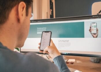 man in black suit holding white iphone 5 - N26 Mastercard. Model holding a phone with the N26 App and website.  , tags: de mastercard des - unsplash