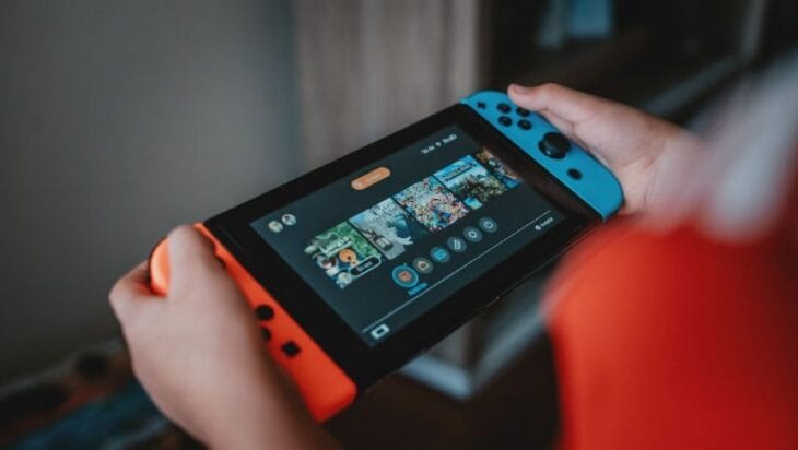 person holding black and orange nintendo switch - Nintendo Switch!, tags: de shiver - unsplash