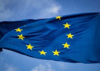 blue and yellow star flag - Flag of the European Union in front of the EU-Parliament in Brussels, Belgium, tags: sur les systèmes - unsplash